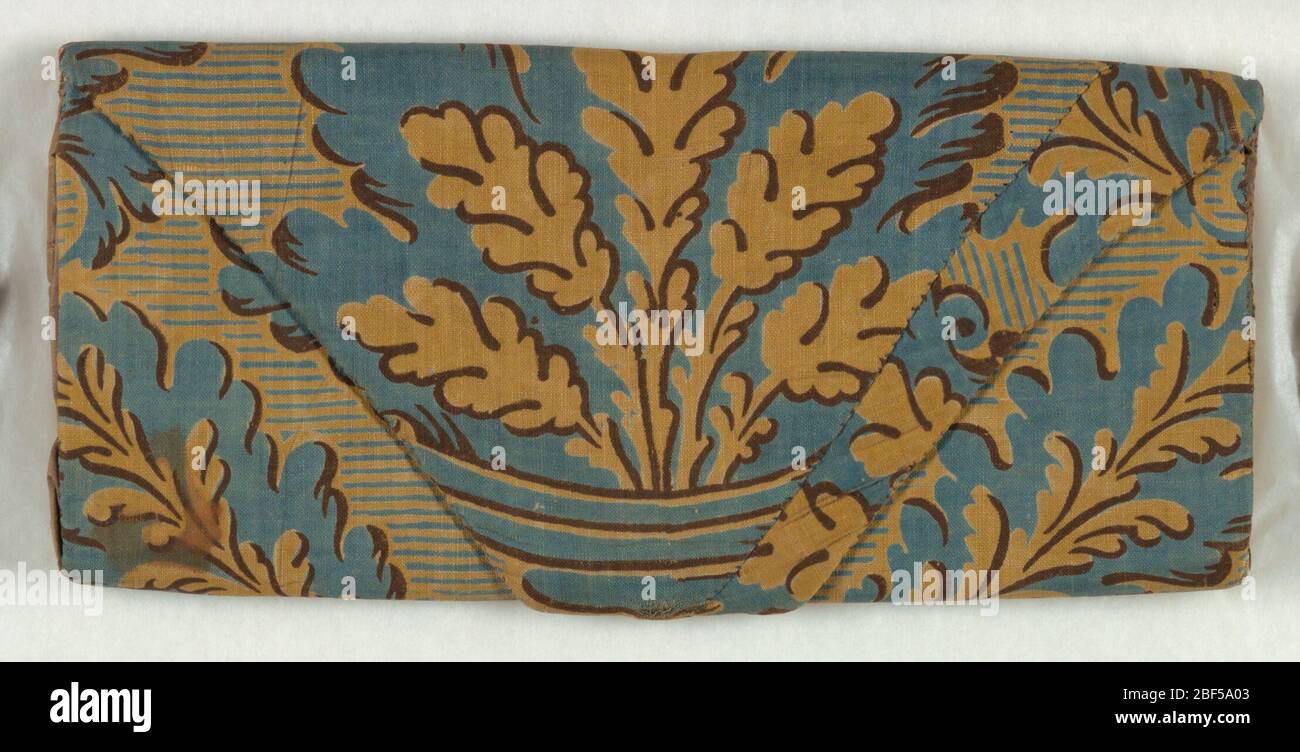 Brieftasche. Mappe- oder Briefkasten mit einem Baumwolldruck von großformatigen Blättern in einer Vase in Gelb, Blau und Braun bedeckt. Mit lila Seide gefüttert. Stockfoto