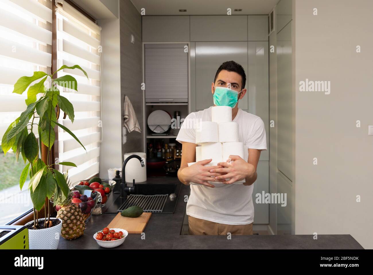 Ein Mann freut sich über das erworbene toilettenpapier wegen der Panik und des Mangels, der durch den Ausbruch des Kovid19-Virus verursacht wurde. Konzeptionelles Foto über Stockfoto