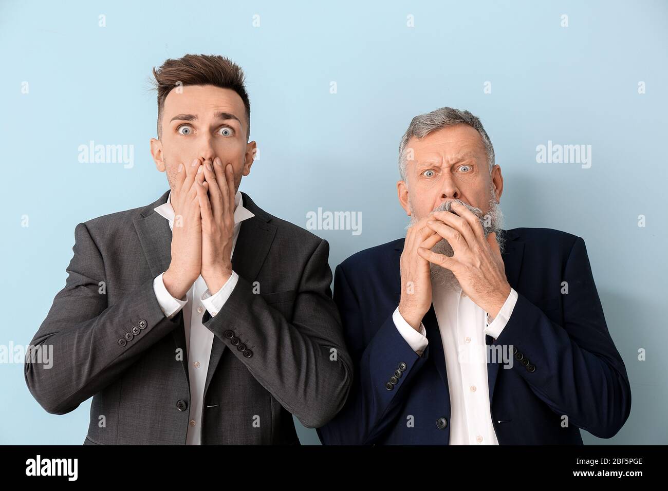 Angst Senior Mann und sein erwachsener Sohn auf farbigen Hintergrund Stockfoto