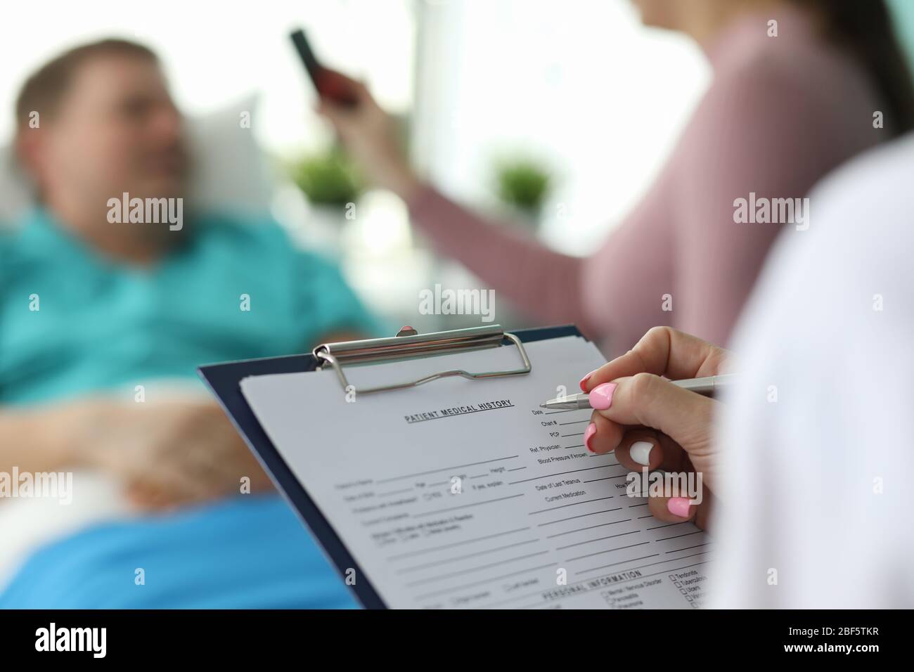 Ärztin füllt Krankenakte des Patienten aus Stockfoto