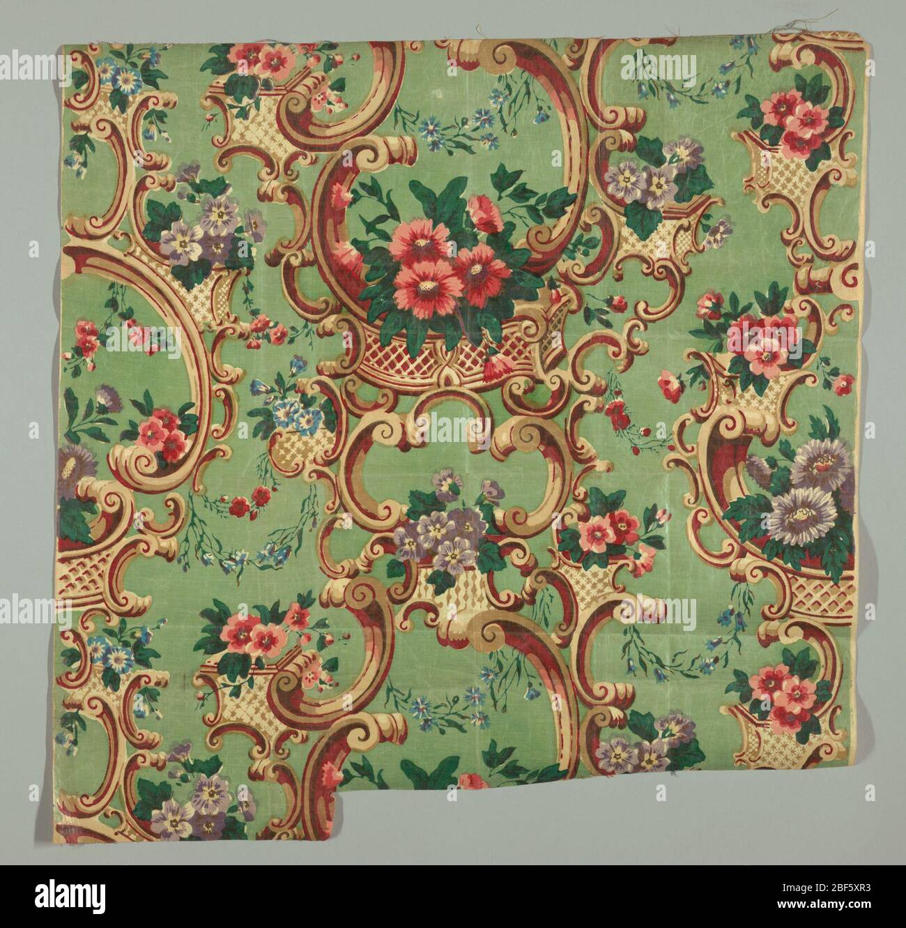 Textil. Blumen in polychromer Farbe und aufwendige Farbskeletchen in braun und rot auf grünem Grund. Stockfoto