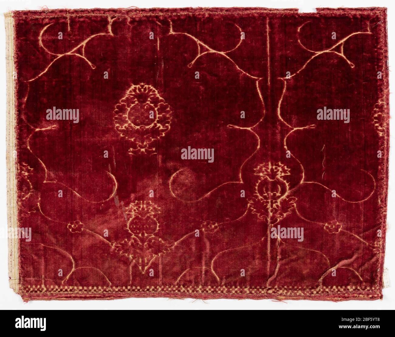 Textil. Tief rot geschnitten und Samt mit einem Design von gelappten Medaillons mit einem zentralen Ananas- oder Granatapfel-Motiv, in der linearen Stil. Stockfoto