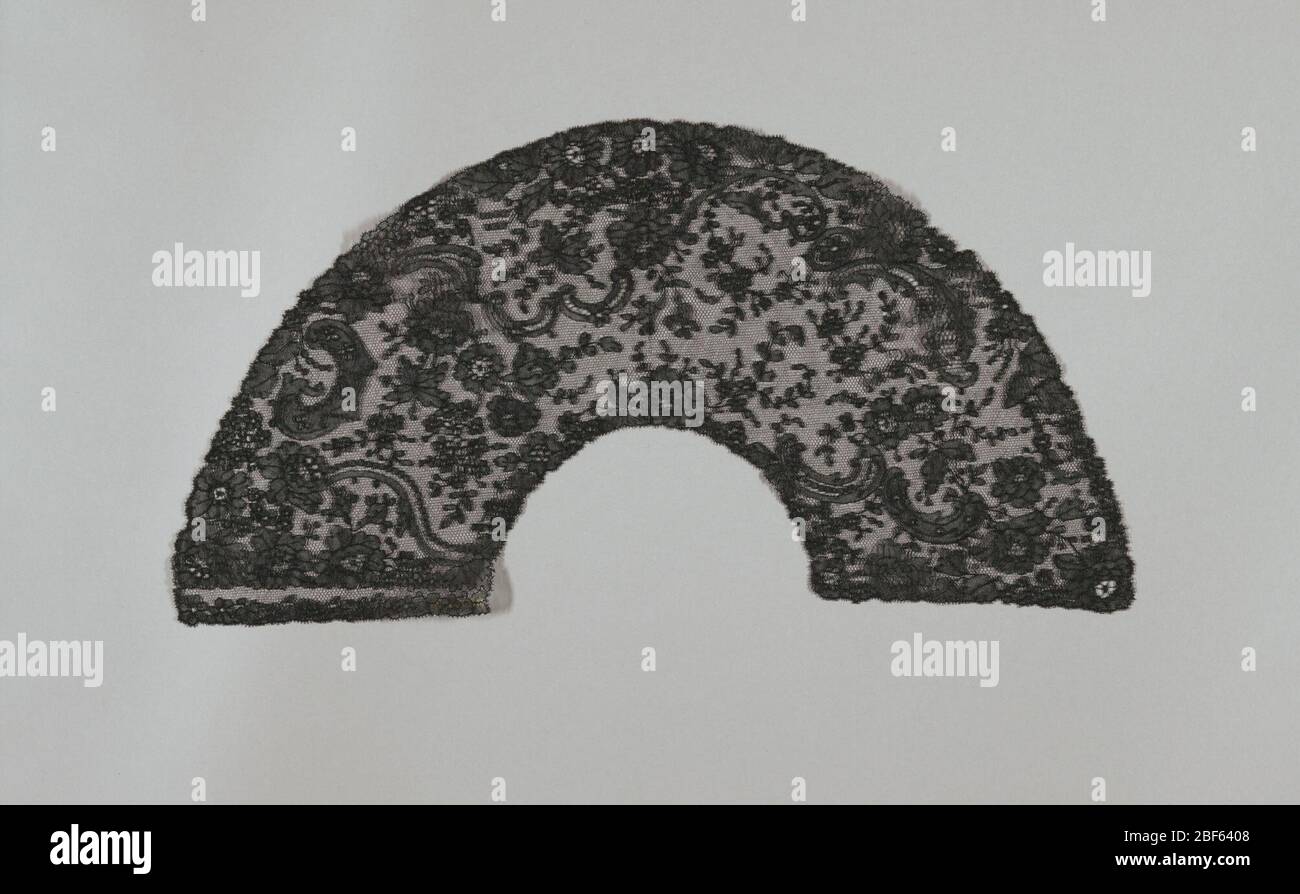 Lüfterblatt. Schwarzes Spulenblatt im Chantilly-Stil mit Design von blühenden Sprays und Schriftrollen. Stockfoto