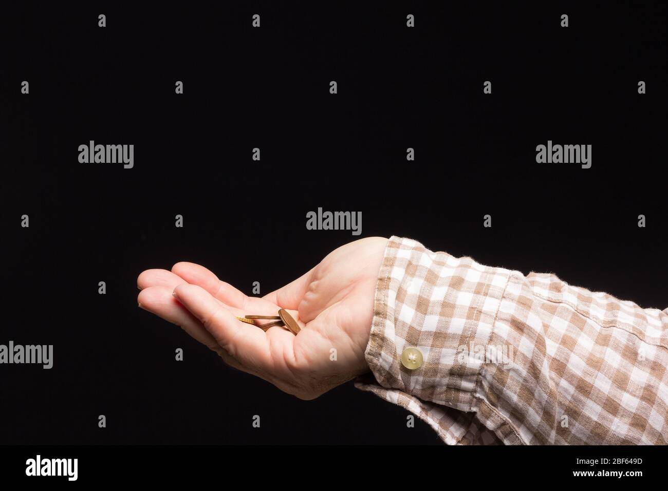 Almosen in der Hand eines weißen Erwachsenen, Bettler um Geld bitten. Münzen in der Hand eines Erwachsenen, um kleine Einkäufe in Nachbarschaftsläden zu tätigen. Pennies in h Stockfoto