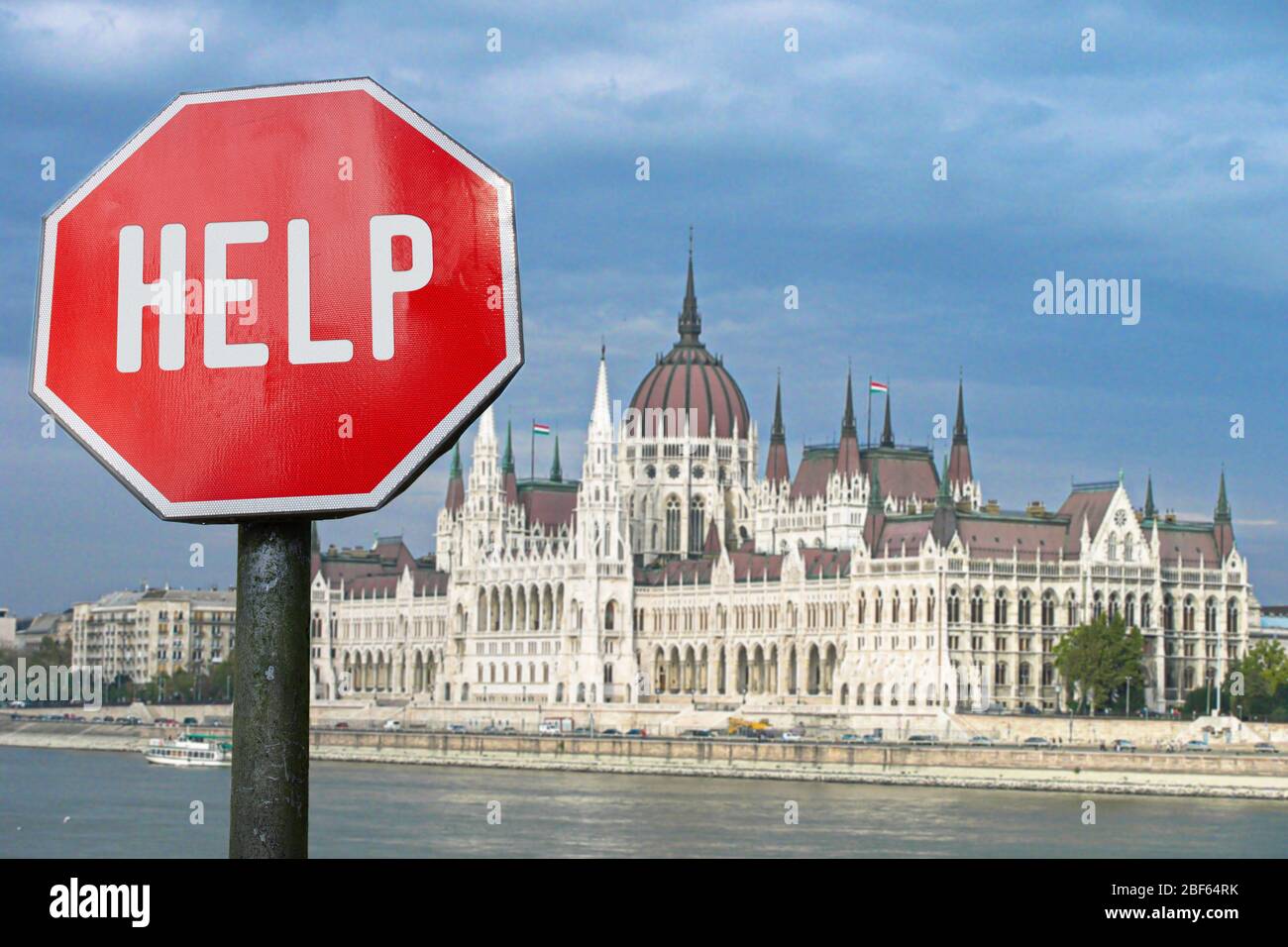 Help stop sign with view of parliament in Budapest, Hungary. Humanitarian and economic help during economic crisis and coronavirus pandemic. Stockfoto