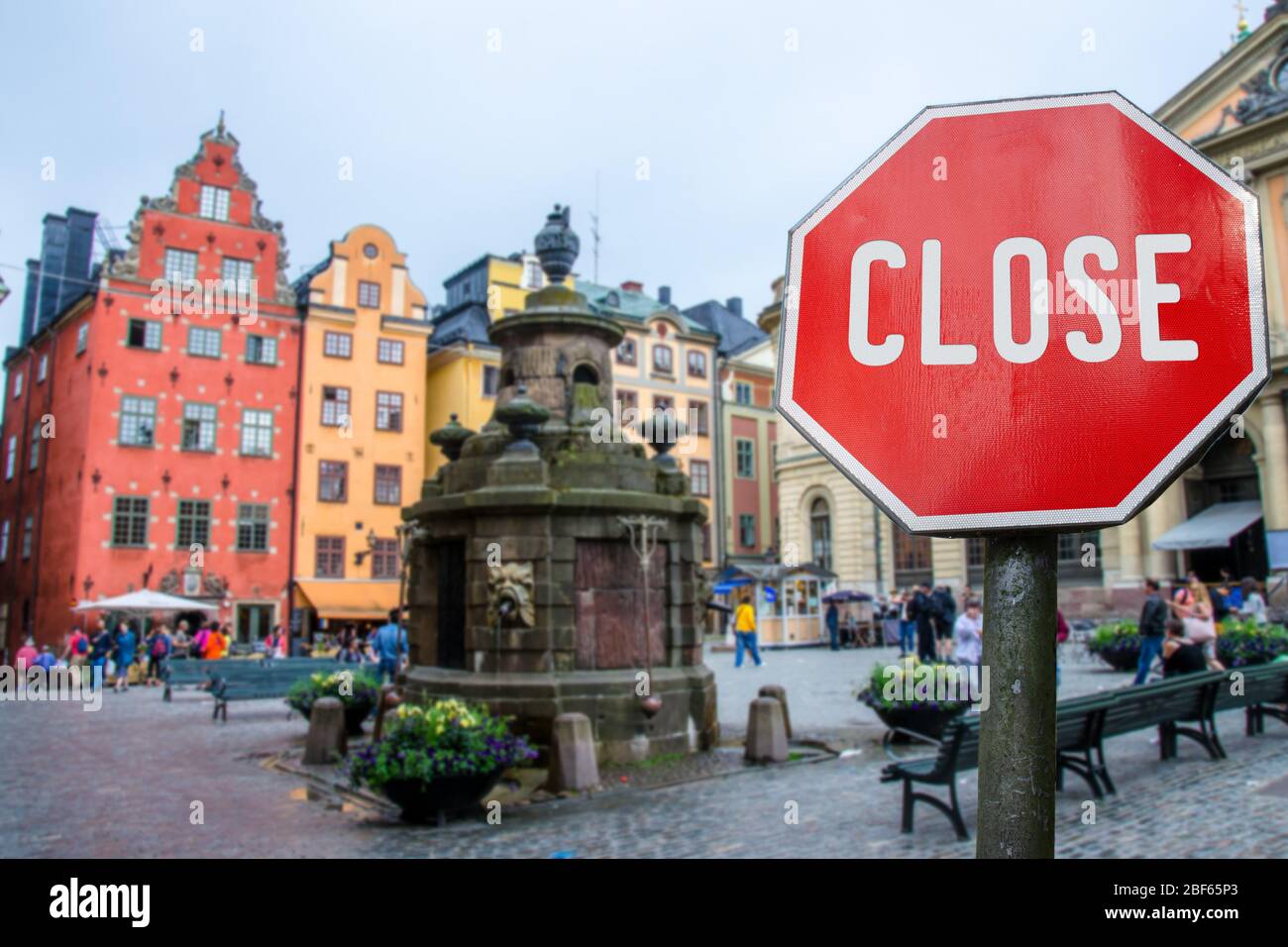 Geschlossenes, geschlossenes Stoppschild mit Blick auf das historische alte Towin in Stockholm, Schweden. Geschlossene Einrichtungen wegen Corona-Virus. COVID-19 Pandemiequarantäne. Stockfoto