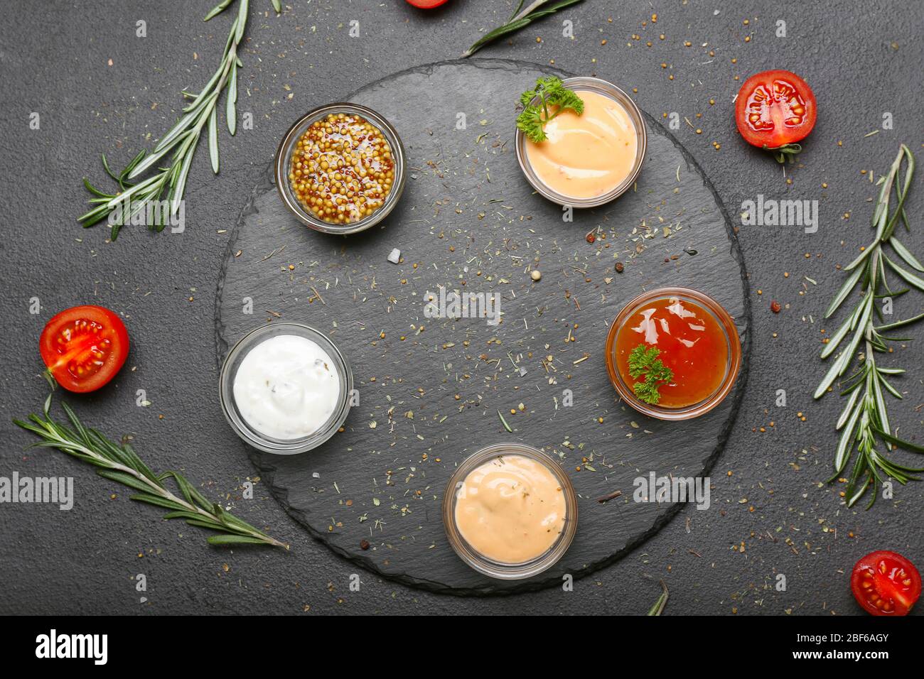 Verschiedene leckere Saucen auf dunklem Hintergrund Stockfoto