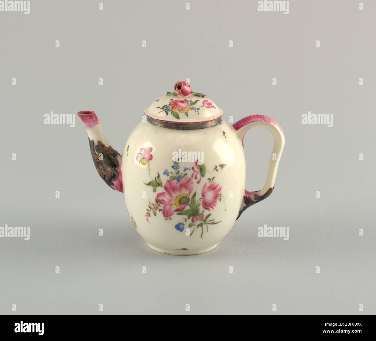 Abdeckung. Ovoider Körper mit Ohrbügel. Florales Finial auf dem Deckel und bemalte Blumendekoration auf Deckel und Körper. Oxidiertes Silber an Rand, Ausguss und unterem Griff. Stockfoto