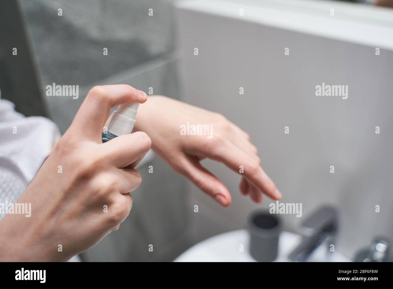 Frau mit einer Flasche Handdesinfektionsmittel Stockfoto