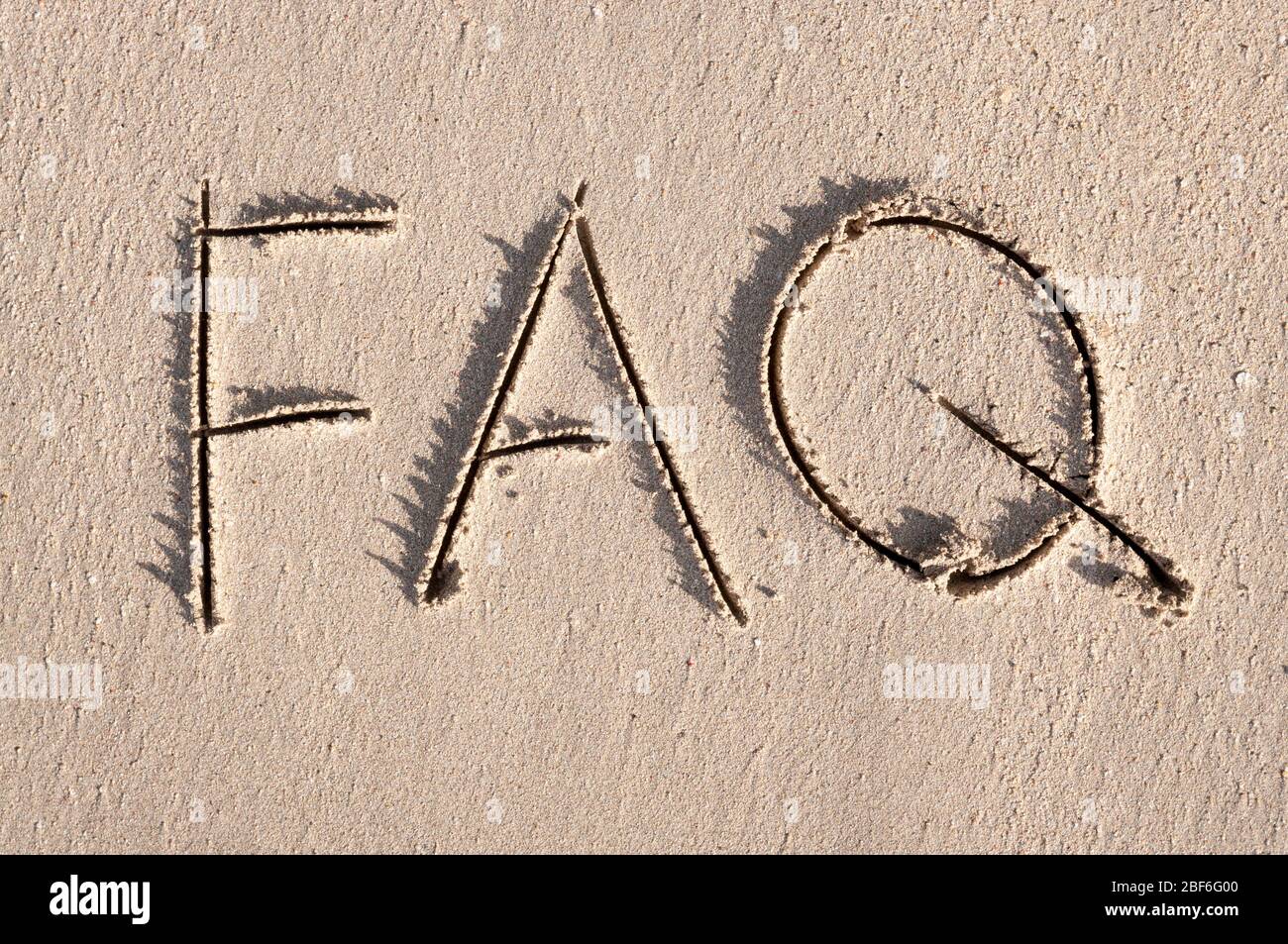 Einfache FAQ-Nachricht, die Abkürzung für Häufig gestellte Fragen, handgeschrieben im Freien auf sauberen glatten Sandstrand Stockfoto