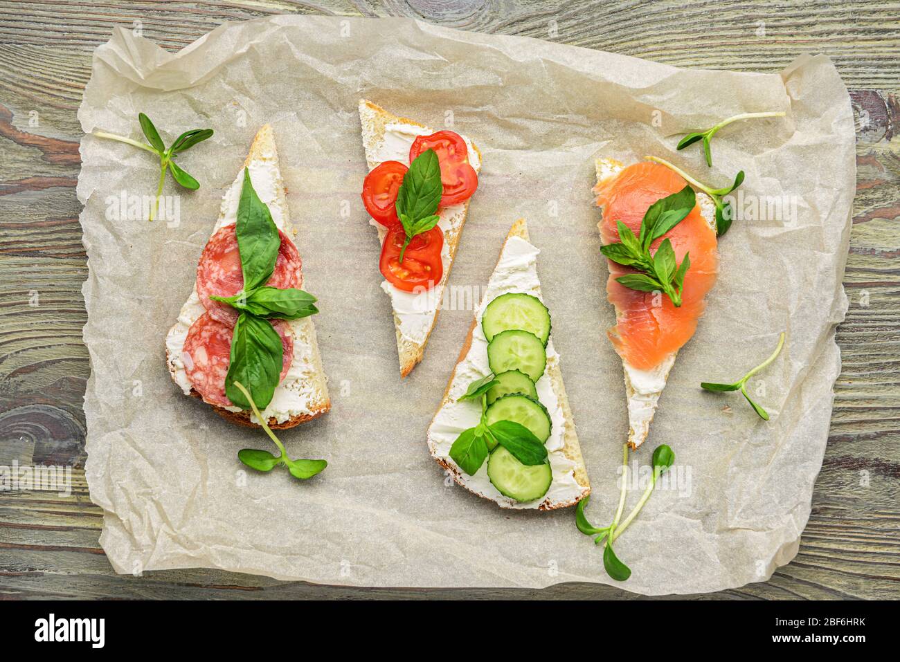 Sandwiches mit leckerem Frischkäse auf Holzhintergrund Stockfoto