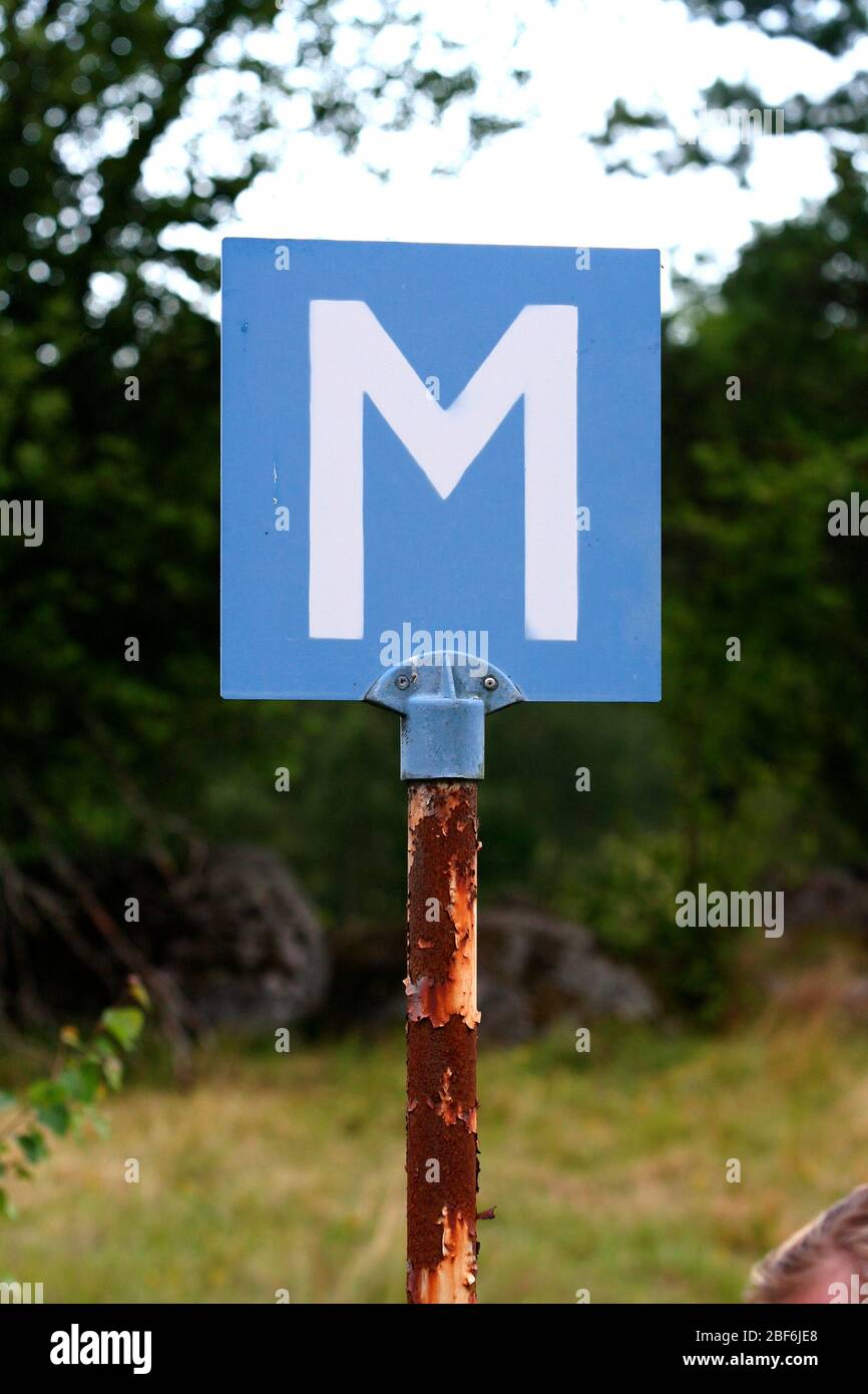 M steht für „MEETING“. Ein altes Schild an einer kleinen Straße. Halten Sie hier Ihr Auto an, um ein anderes vorbeifahren zu lassen. Stockfoto