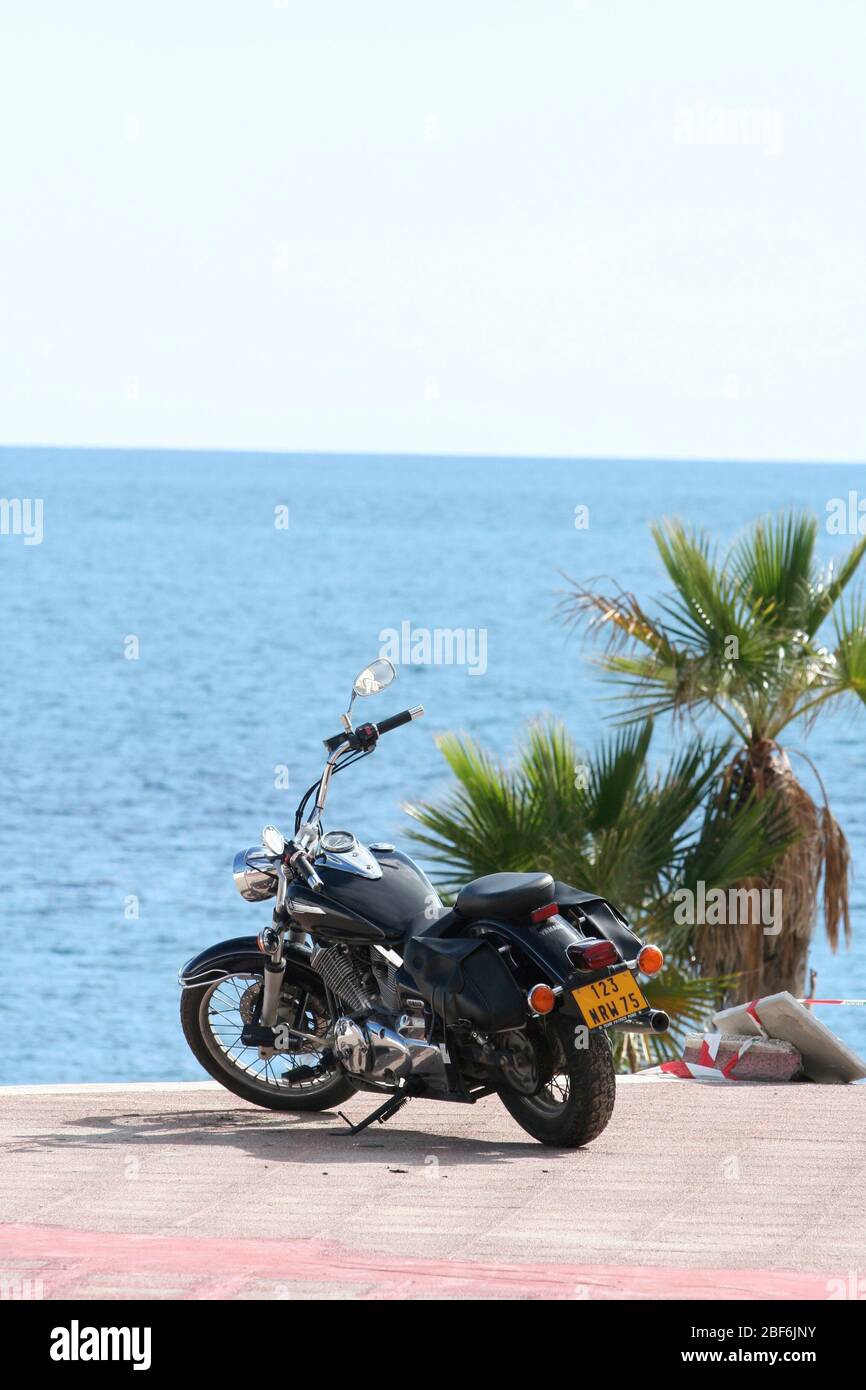 Ein Motorrad am Meer in Puerto Banus, Spanien geparkt Stockfoto