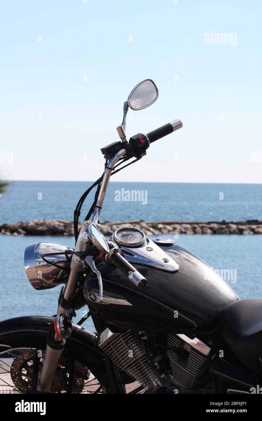 Ein Motorrad am Meer in Puerto Banus, Spanien geparkt Stockfoto