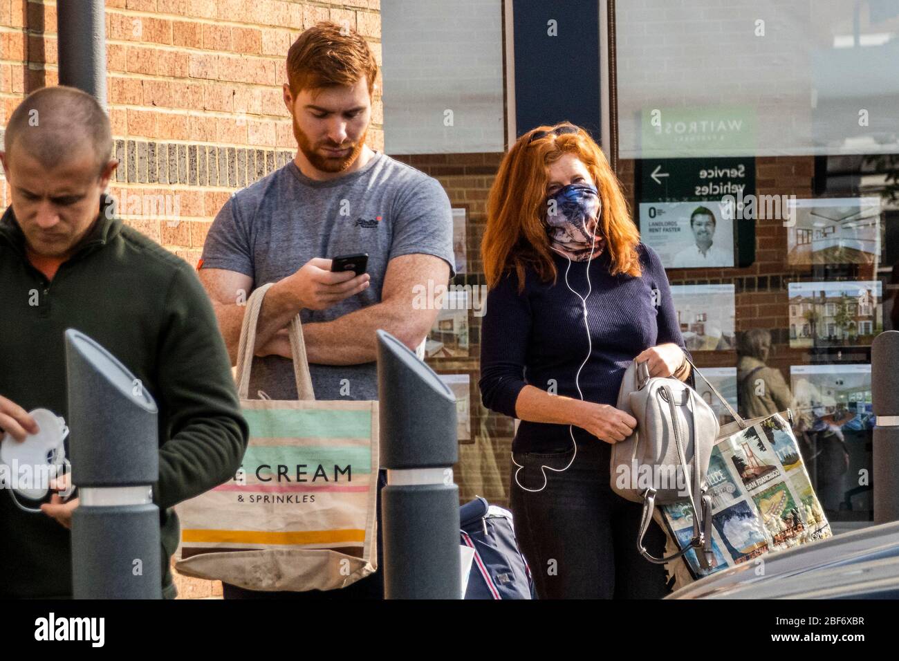 London, Großbritannien. April 2020. Masken werden von vielen in der Warteschlange getragen und mangelnde Technik bei der Umsetzung zeigt, warum ihre Verwendung für nicht-Profis begrenzt ist - Käufer Schlange stehen und mit Sorgfalt bei Waitrose Balham einkaufen. Die 'Lockdown' geht in London wegen des Coronavirus (Covid 19) Ausbruchs weiter. Kredit: Guy Bell/Alamy Live News Stockfoto