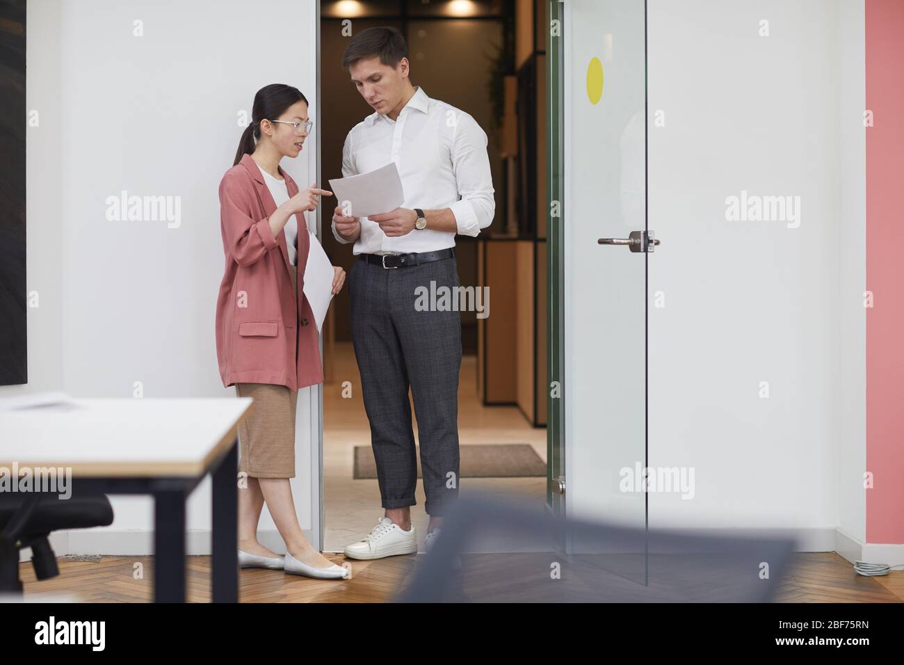 Junger Geschäftsmann Beratung mit seinem Kollegen über Geschäftsdokumente stehen sie im Büro Stockfoto