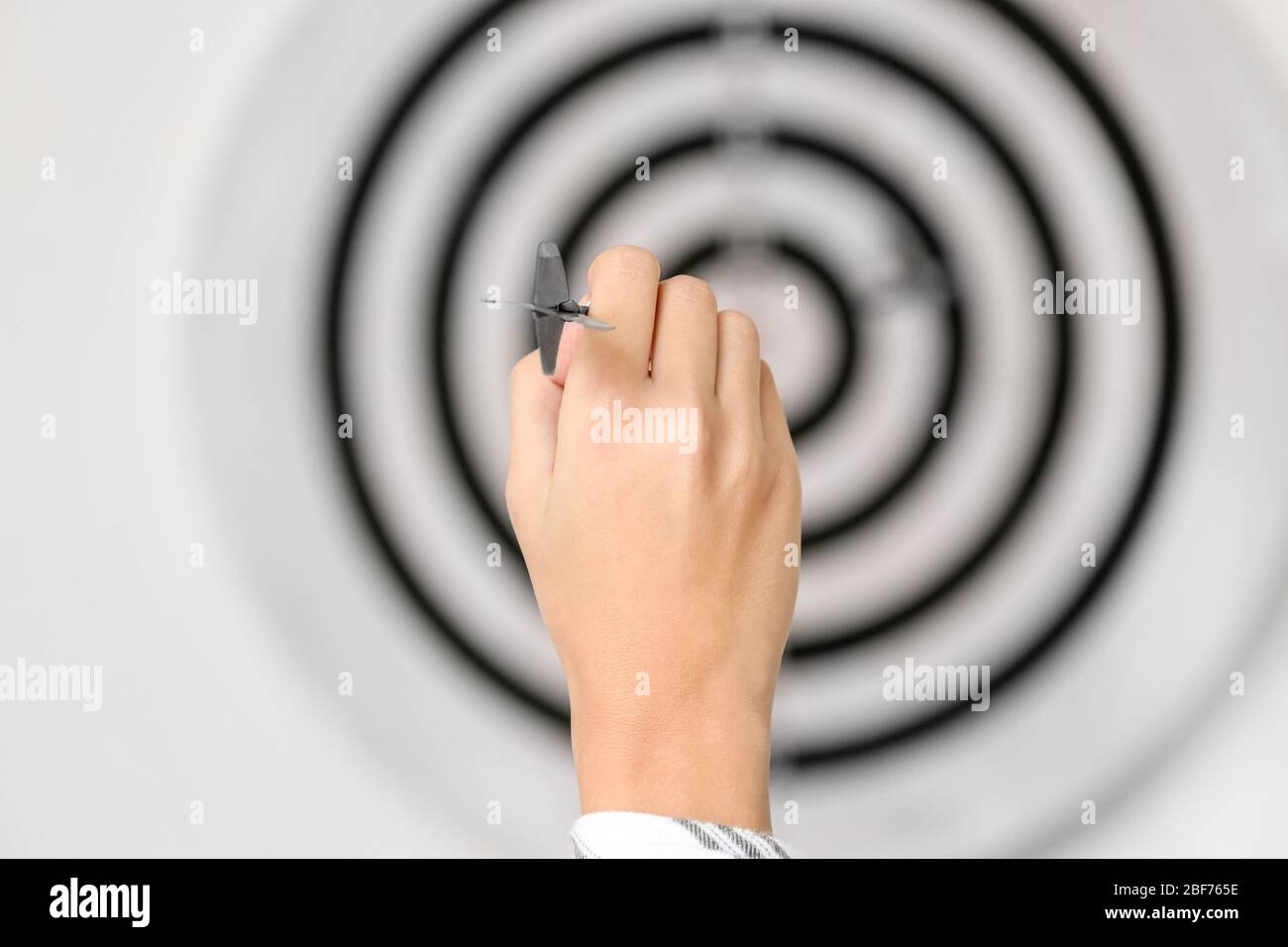 Junge Frau, die Dart im Haus spielt, Nahaufnahme Stockfoto