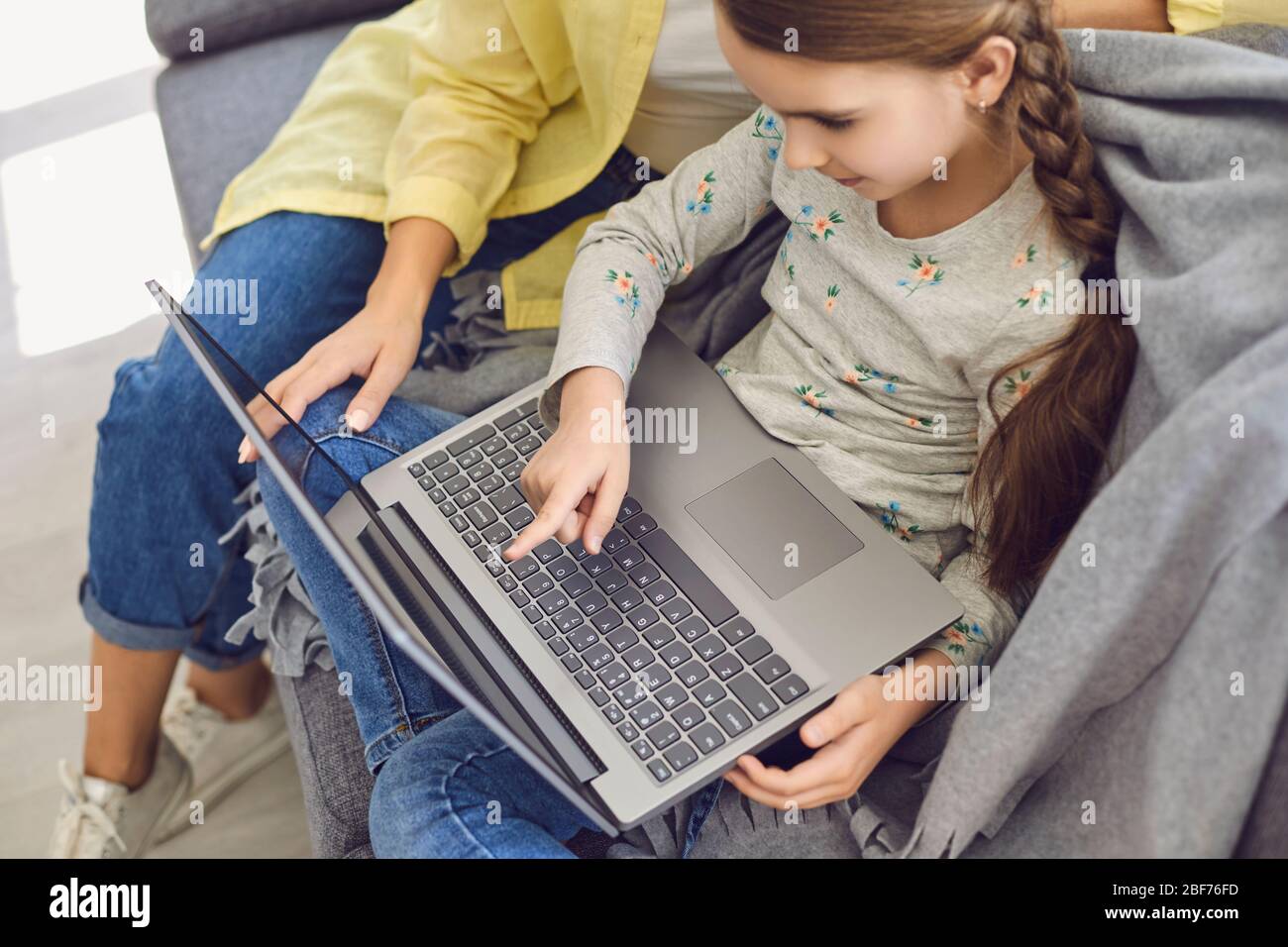 Mutter und Tochter verwenden Laptop online kaufen Training Lektion Video zu Hause sitzen. Stockfoto