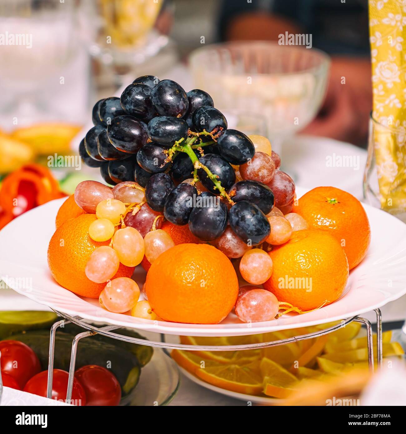 Obsttrauben, Orangen, Tangerinen, Zitrone auf dem Ferientisch Stockfoto