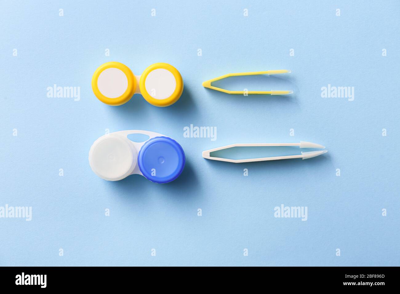 Behälter mit Kontaktlinsen und Pinzette auf farbigem Hintergrund Stockfoto