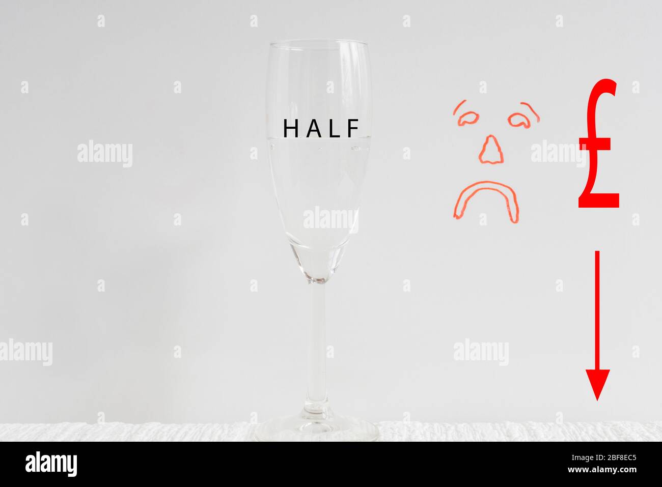 Ein Weinglas, halb voll mit gezeichnet traurig Gesicht im Hintergrund Darstellung Konzept von Glas halb leer. Stockfoto