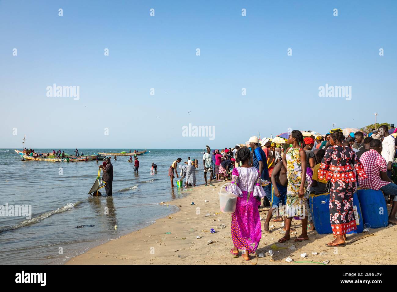TANJI, GAMBIA - 21. NOVEMBER 2019: Menschen, die Fische von den Booten zum Strand auf Tanji, Gambia, Westafrika, tragen. Stockfoto
