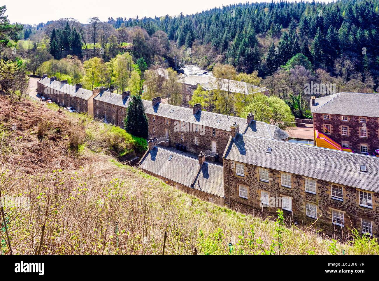 Blick auf New Lanark Heritage Site in der Nähe von Lanark in Lanarkshire Schottland von dem Weg, der vom Parkplatz hinunter führt. Stockfoto