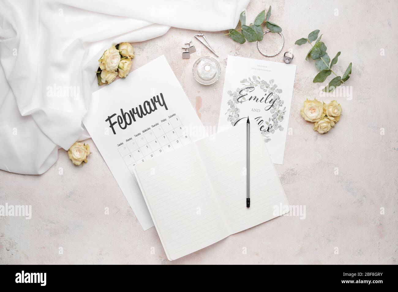 Notizbuch mit Hochzeitseinladung und Kalender auf hellem Hintergrund Stockfoto