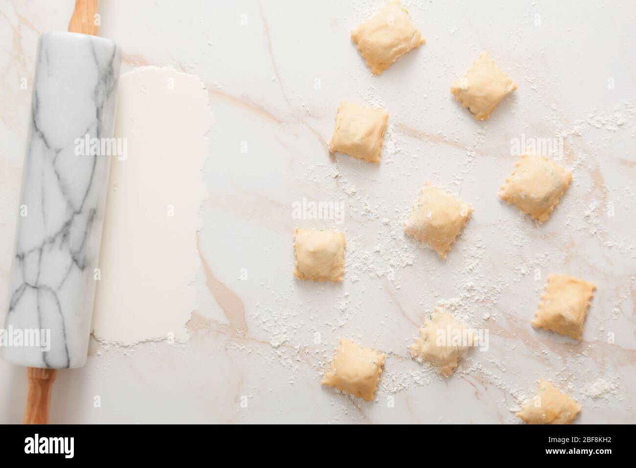 Ravioli roh mit Nudelholz auf weißem Hintergrund Stockfoto