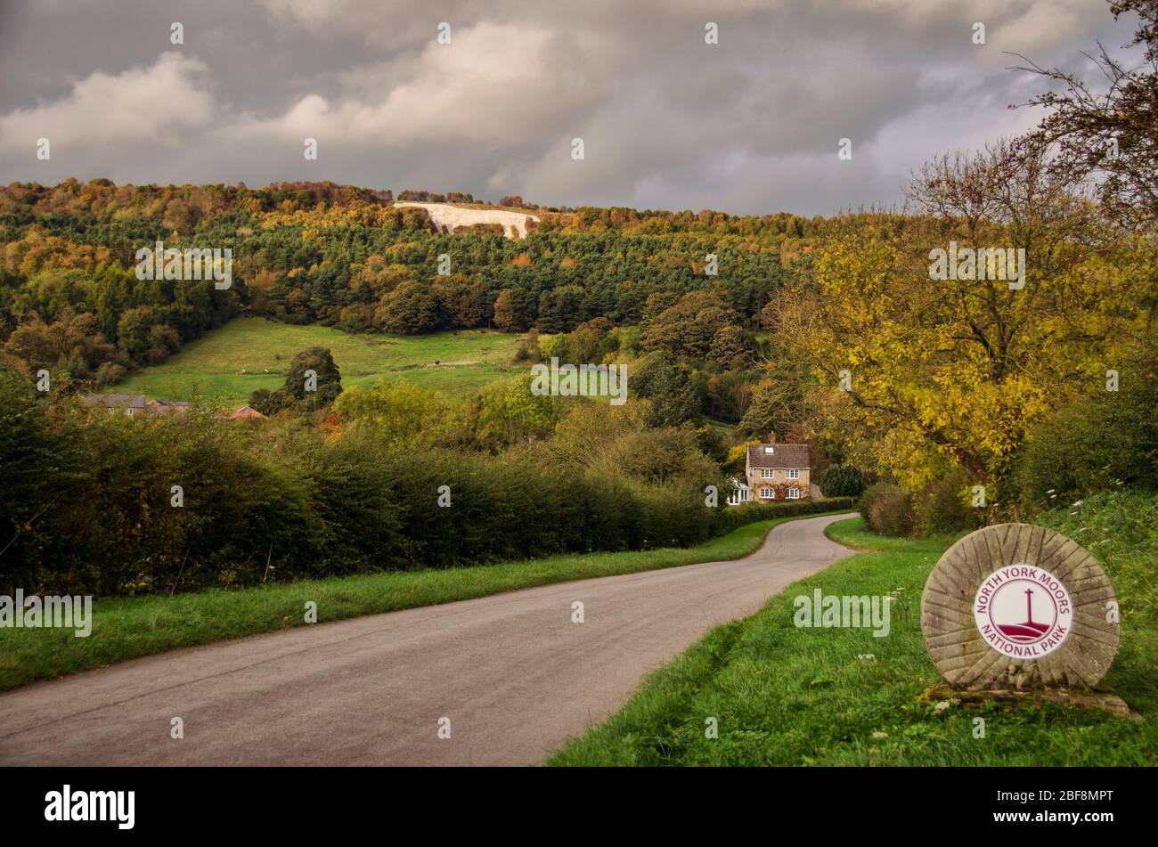 Das Weiße Pferd der Sutton Bank, auf dem Hügel bei Kilburn Bank geschnitzt, mit einem Grenzstein markiert den Beginn der North York Moors Nation Stockfoto