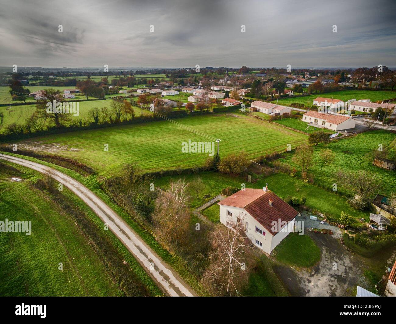 Das Einzelhaus steht an einem Sommertag allein in einem französischen Dorf, aber mit dunklen Wolken, die am Horizont ankommen Stockfoto