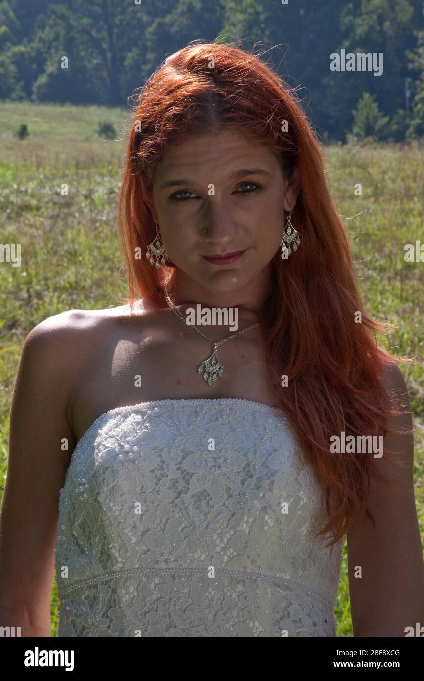 Rotschopf Frau in einem Hochzeitskleid im Freien, Stockfoto
