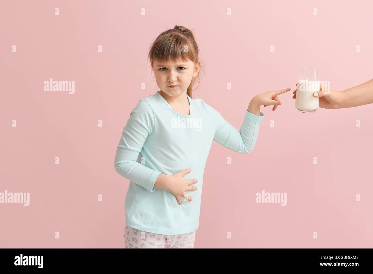 Kleines Mädchen mit Milchallergie auf farbigem Hintergrund Stockfoto
