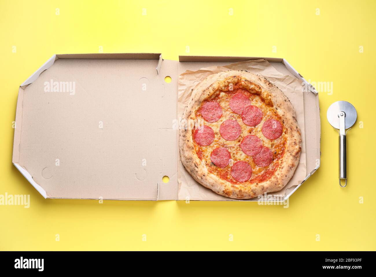 Box mit leckeren Pizza auf farbigen Hintergrund Stockfoto