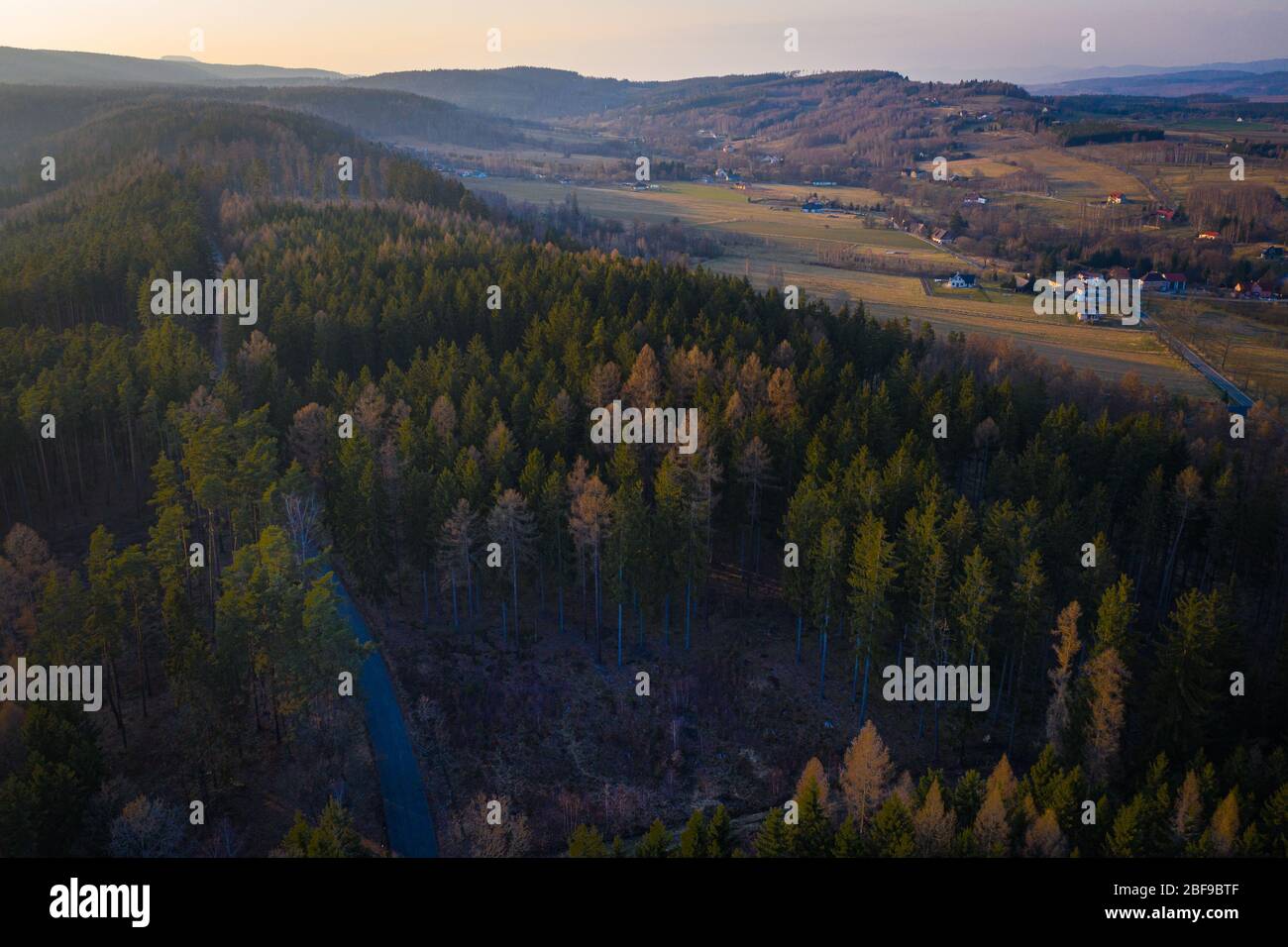 Kleines Dorf zwischen Ackerland und Waldfläche - schöne Frühlingslandschaft in der Nähe von Batorówek, Tafelberge, Polen. Aussicht Stockfoto