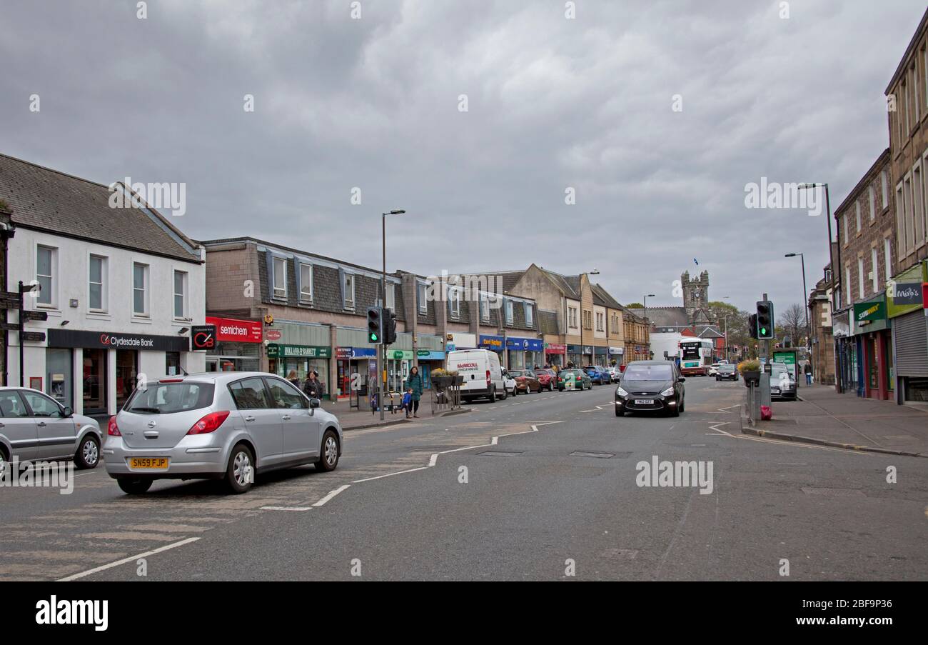 Musselburgh, High Street, East Lothian, Schottland, Großbritannien. Die normalerweise geschäftige Hauptstraße zeigt in normalen Zeiten sehr ruhige Gehwege wegen der Coronavirus-Sperre, aber mehrere Autos, die durchfahren. Der verkehrsreichste Bereich für Fußgänger war außerhalb Boots, der Apotheke, wo die Leute in der Warteschlange soziale Distanz hatten. Stockfoto