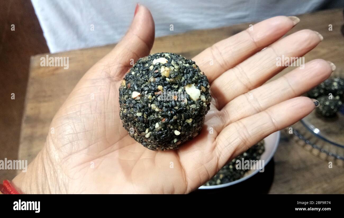 Schwarze Sesamkügelchen - süß mit Sesam und Palmzucker. Tilgul Laddu oder Til Gul Bälle für Makar sankranti, geröstete thala Bälle. Stockfoto