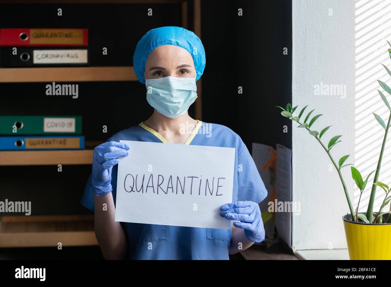 Weibliche Ärztin in blauer Uniform erklärt Quarantäne Stockfoto