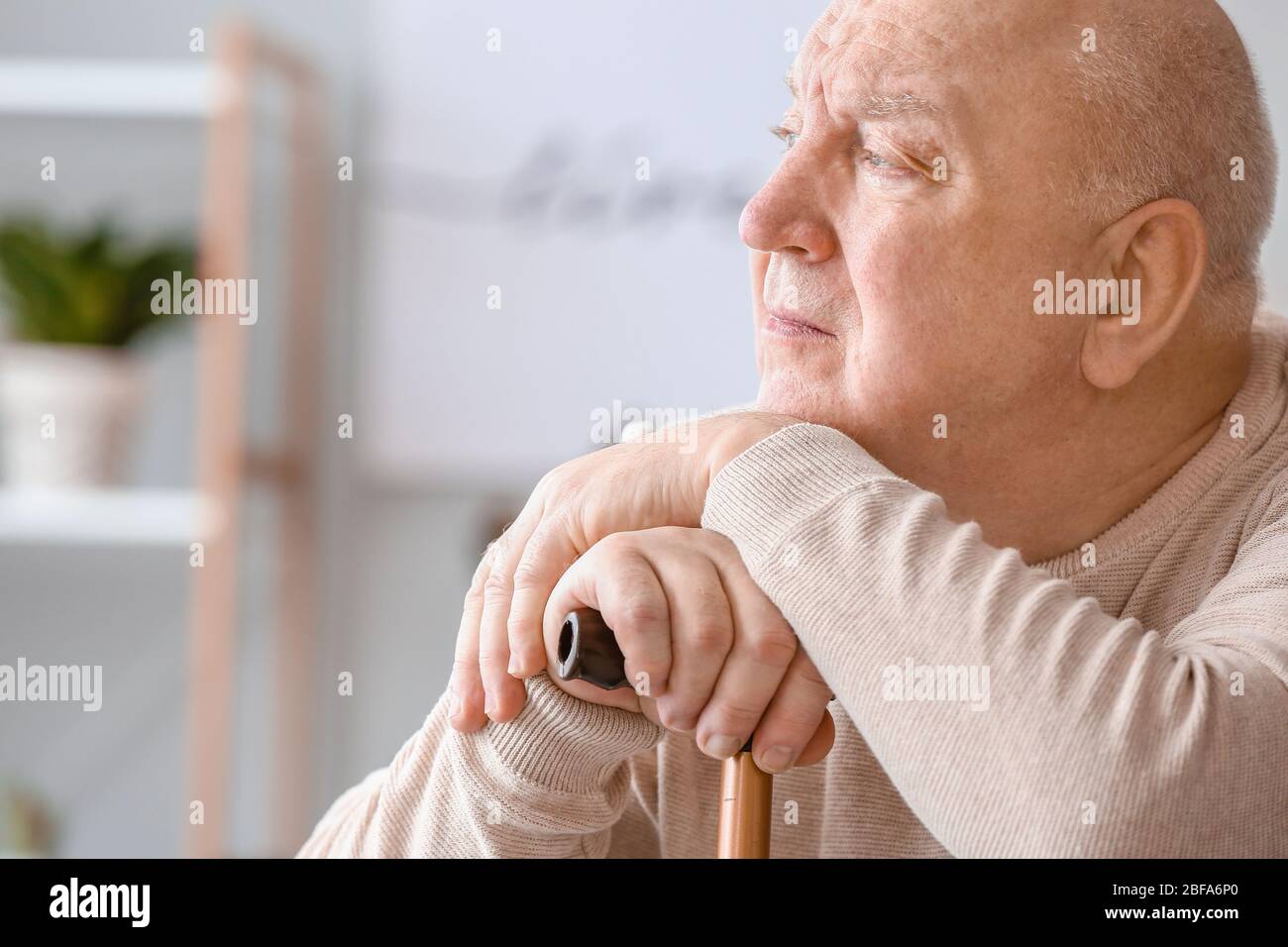 Älterer Mann, der zu Hause an geistiger Behinderung leidet Stockfoto