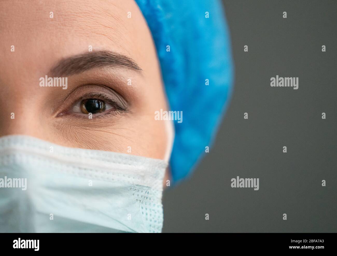 Das Auge der Frau in Schutzmaske schaut auf die Kamera Stockfoto