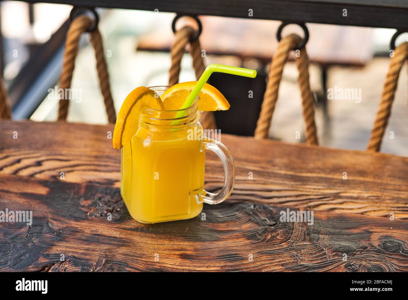 Frisch gepresster Bio-Orangensaft. Speziell gearbeiteter Orangensaft. Exotische alkoholische Cocktails auf einem Holztisch. Orange und gelb rosa weich Stockfoto