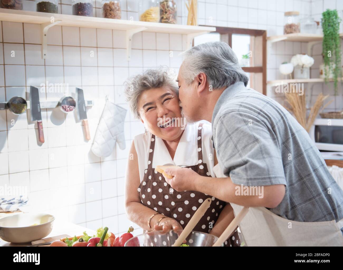 Glücklich asiatische ältere ältere Paar Kochen frische Mahlzeit in der Küche zu Hause. Stockfoto