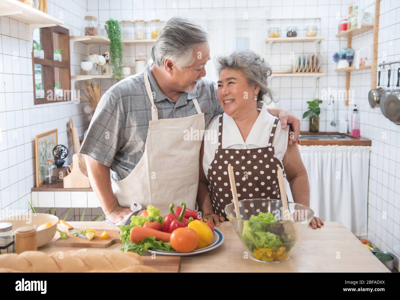 Glücklich asiatische ältere ältere Paar Kochen frische Mahlzeit in der Küche zu Hause. Stockfoto