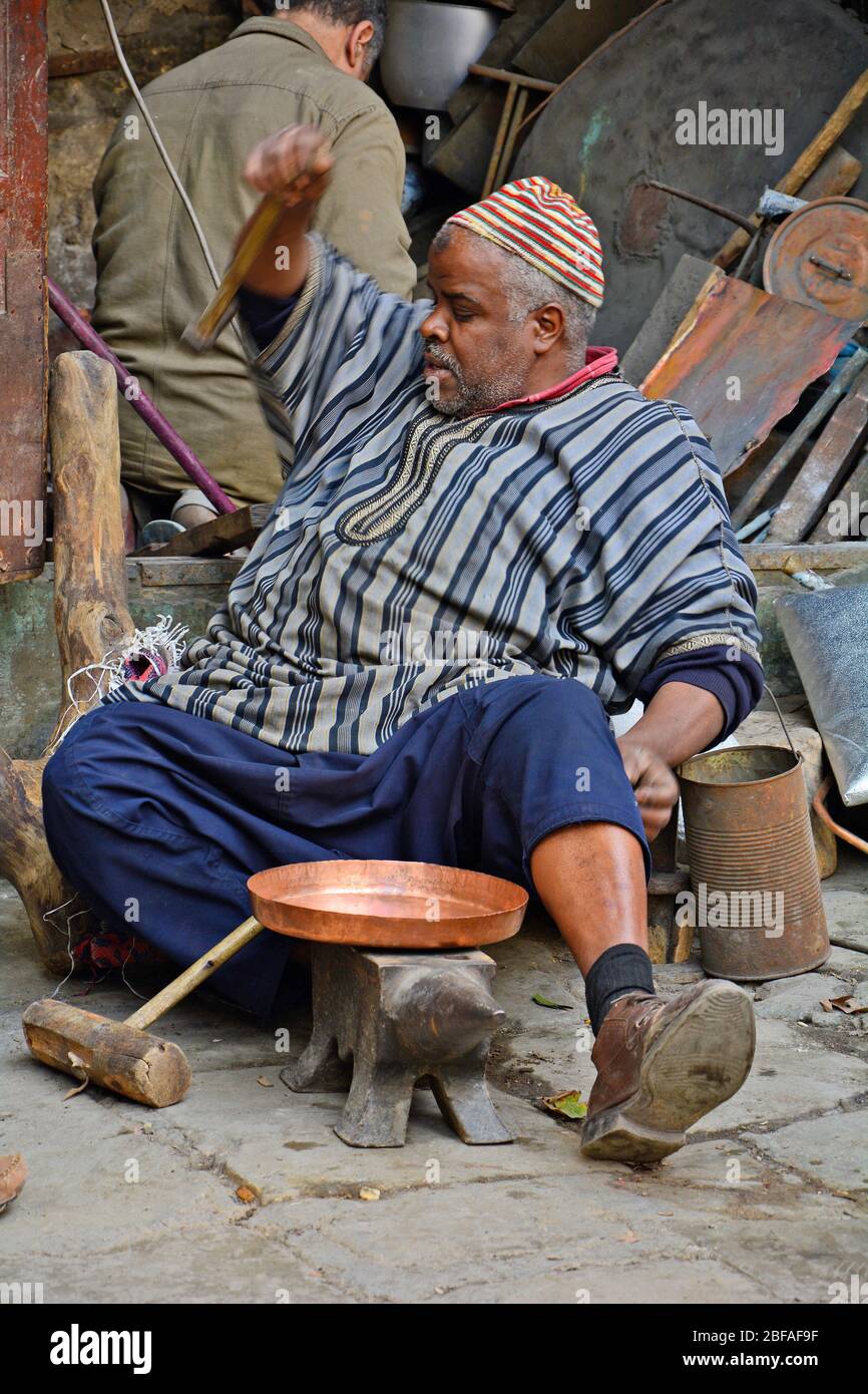 Fes, Marokko - 20. November 2014: Nicht identifizierter Mann, der Messingartikel auf dem Platz es-Seffarine im Souk Fes el-Bali produziert, Platz für Brasswarenarbeiter Stockfoto