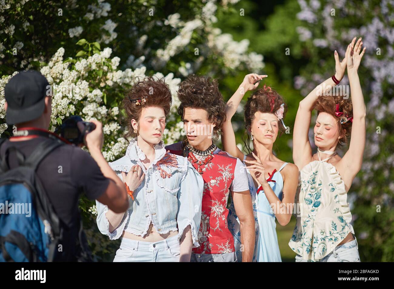 MOSKAU, RUSSLAND - 19. MAI 2019 Modische Hipster-Mädchen und ein Typ posiert für einen Fotografen in blühenden Flieder. Stockfoto