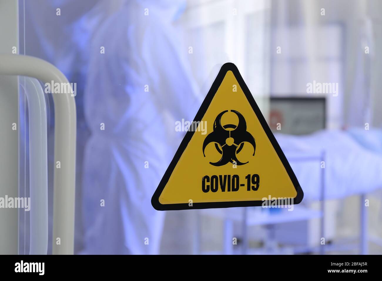 Warnschild für Biohazard an der Tür der ansteckenden Isolationsstation. Konzept der Coronavirus-Epidemie Stockfoto