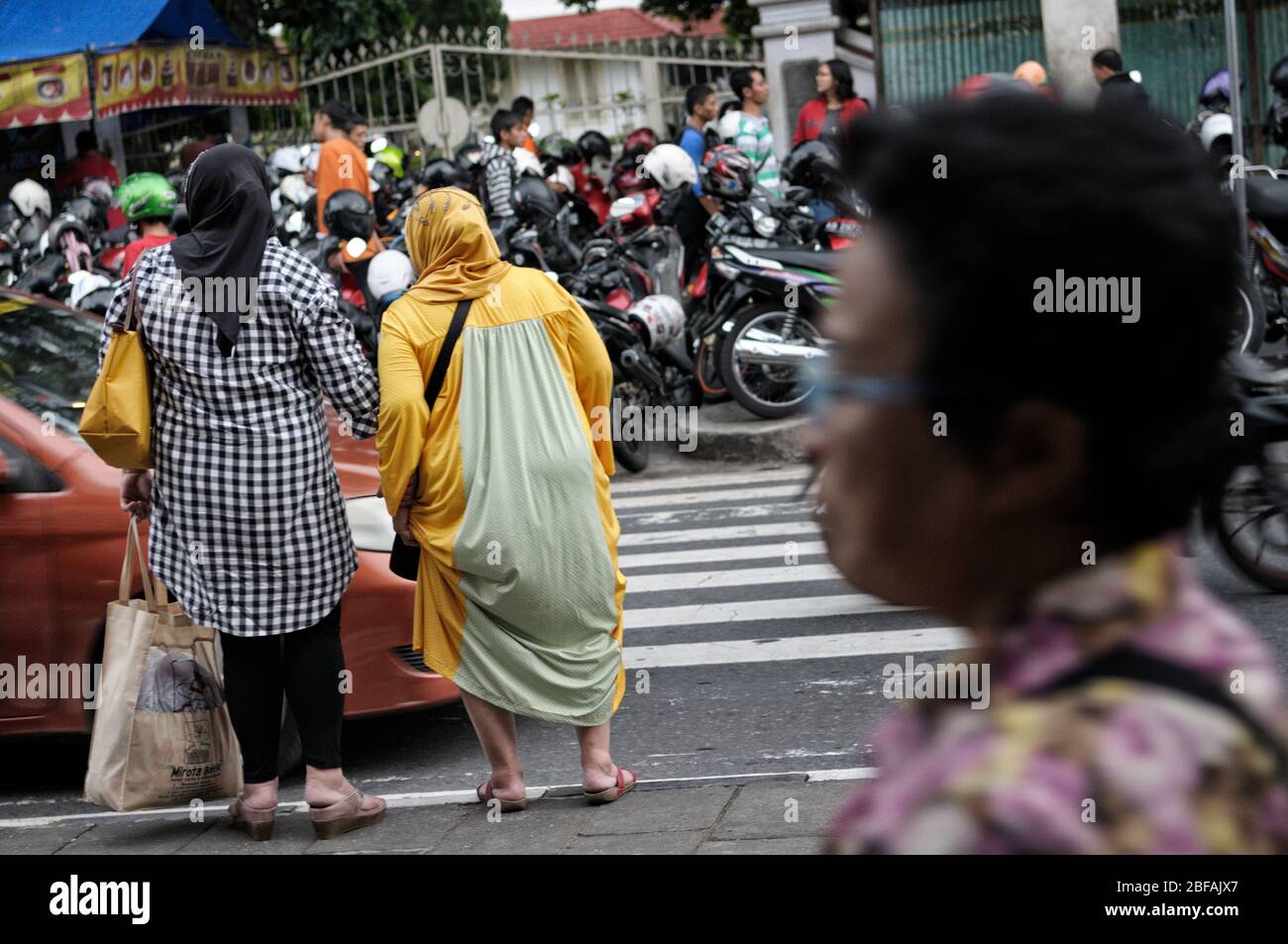 Frauen, die die Straße überqueren wollen in Yogyakarta, Java, Indonesien Stockfoto