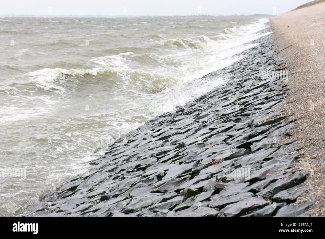 Detailansicht eines mit Steinen befestigten Staudamms an der Nordsee Detailansicht von einem mit Steinen befestigten Deich an der Nordsee Stockfoto