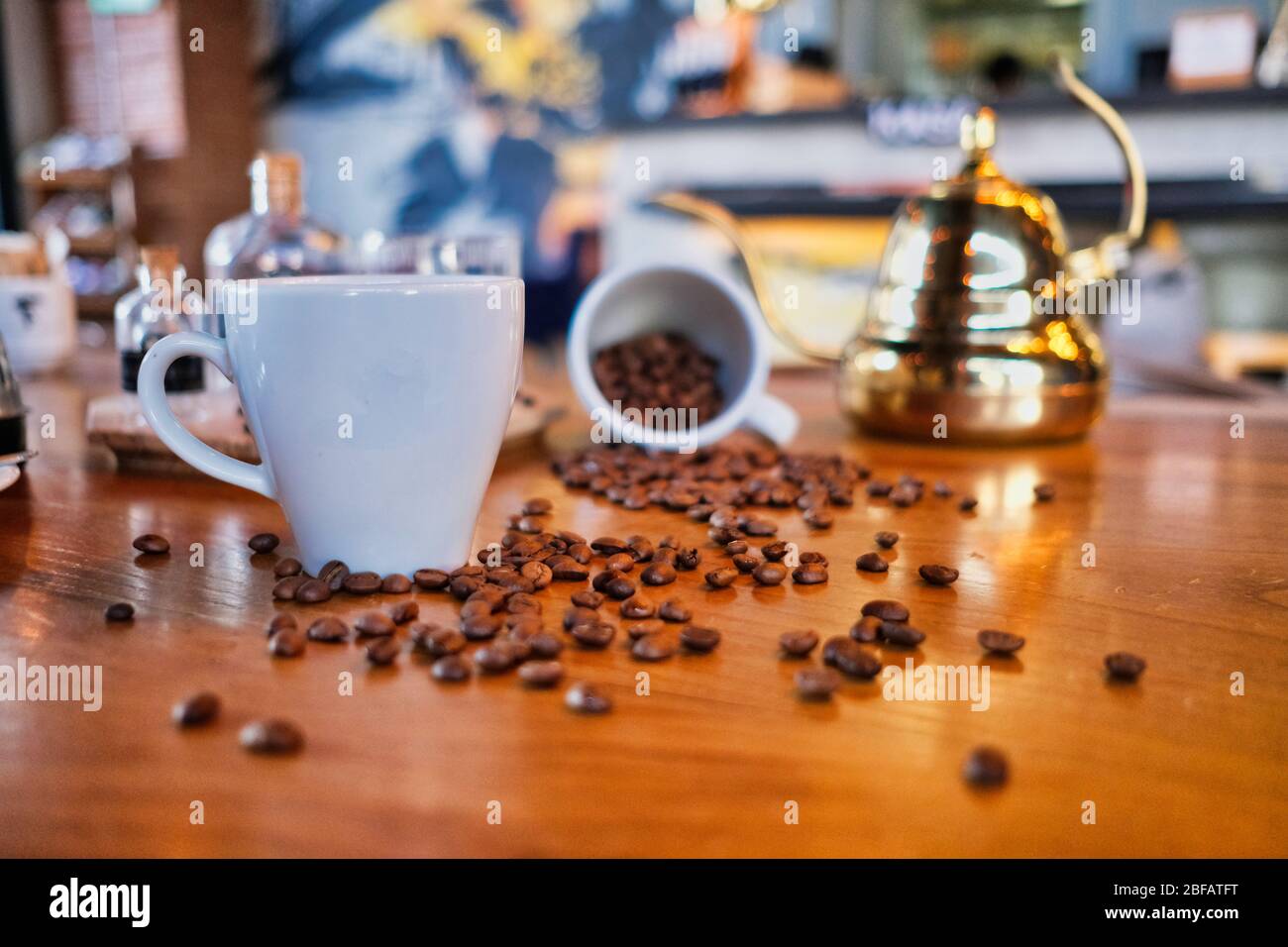 Kaffeetassen mit Kaffeebohnen auf dem Holztisch Stockfoto