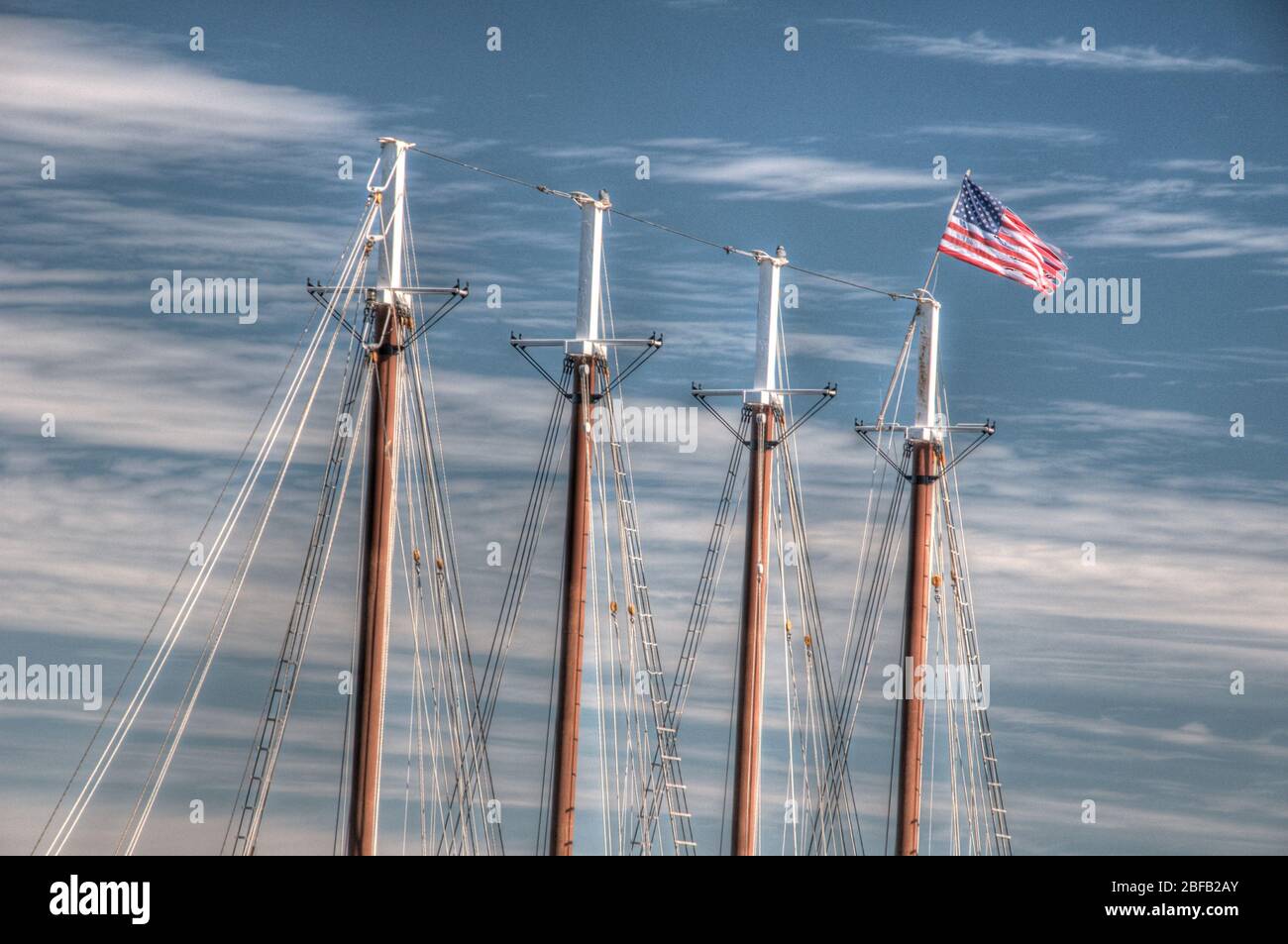 Eine amerikanische Flagge fliegt über einem viermastigen Segelschiff. Stockfoto